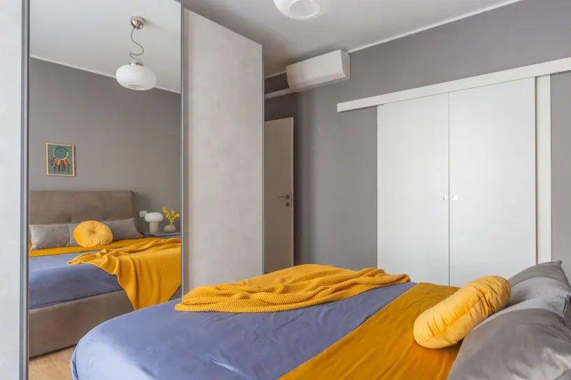 home-staging-di-casa-abitata-arredata-e-fotografia-immobiliare-ca,era-da-letto-con-cuscino-leroymerlin-e-coperta-gialla-maison-dumond-e-riflesso-nello-specchio